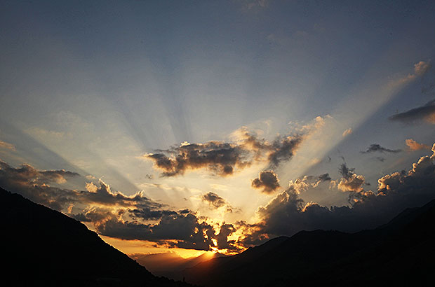 Round dance of rays at sunset. Amazing evening in the mountains of Georgia