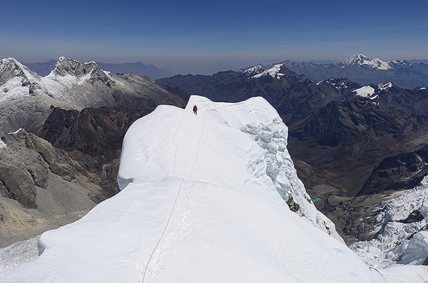 On the snow summit of Nevado Alpamayo. Usually there is no access to the main summit from the 'French Route'. But in this season, a wide snow bridge has been blown up and you can risk to walk 70 m more along the exposed ridge to reaching the Main summit of Nevado Alpamayo!