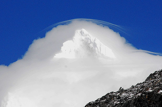 The summit of Alpamayo bathing in the clouds