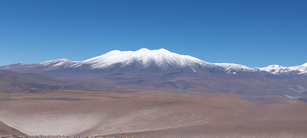 The impressive scale of the high-mountain Puna. View of Nevado Ojos del Salado from the acclimatization summit Cerro Chango 4625 m