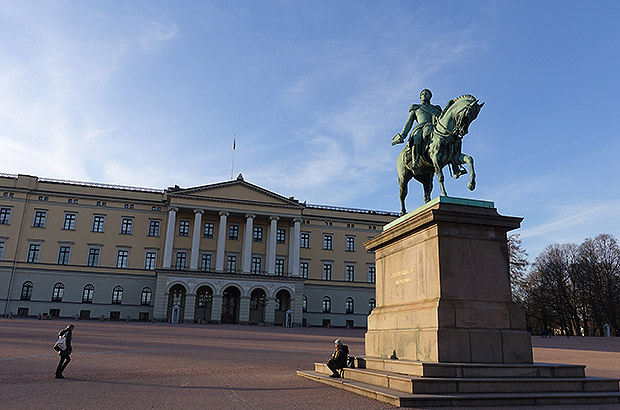 King Karl Johan and his faithful four-legged friend in front of the façade of the royal palace in Oslo, Norway