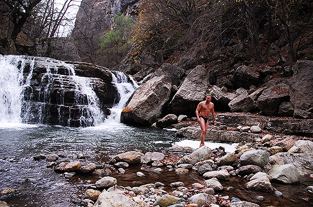 Refreshing bathing in a mountain waterfall during a winter trekking in the mountains of Armenia