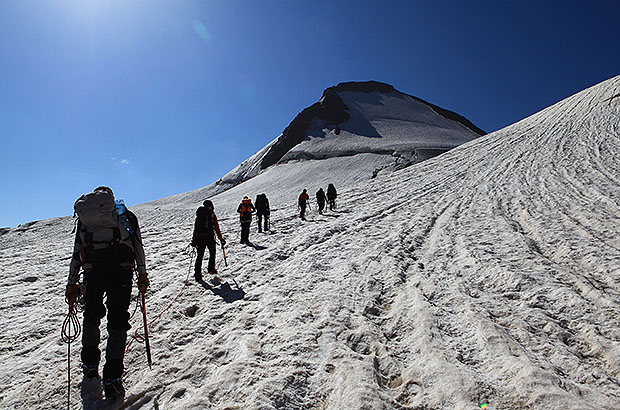 Roped team is passing the glacier plateau.